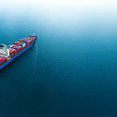 Container ship carrying cargo across open water.
