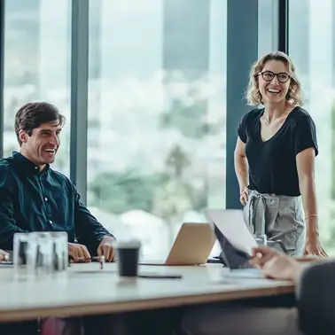 Laughing colleagues having a meeting in a conference room.