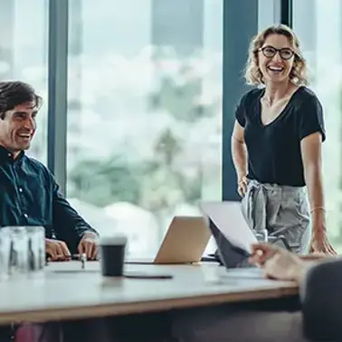Laughing colleagues having a meeting in a conference room.